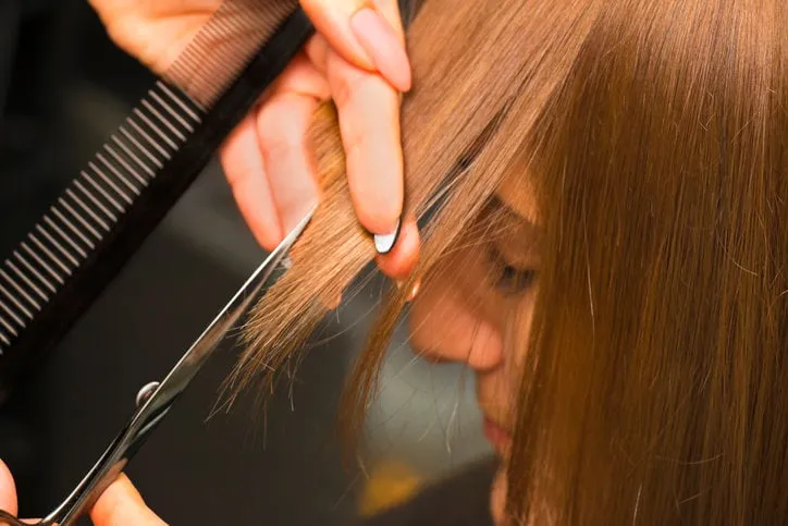 female hair salon customer getting bangs trimmed