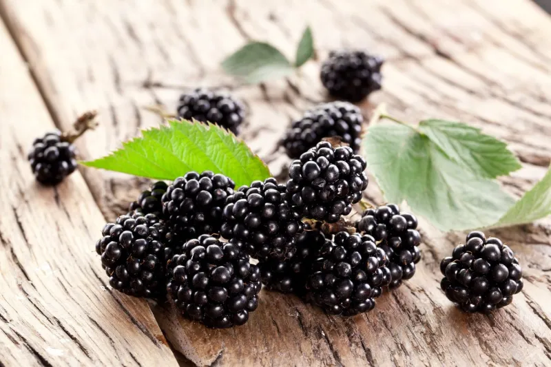 blackberries with leaves on a old wooden table