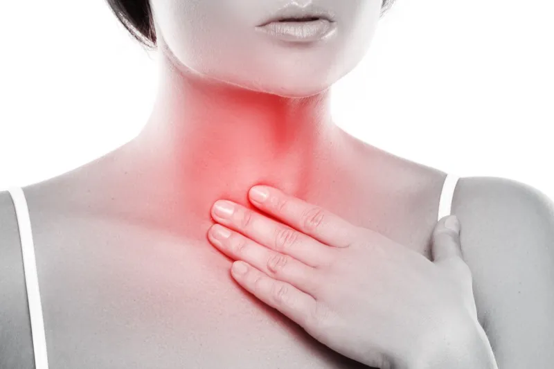 woman with a pain in her throat on white background