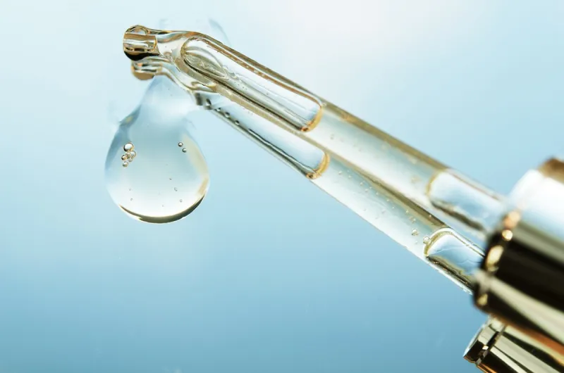 liquid drop from cosmetic pipette close up, on mirror with reflection skin care concept - image