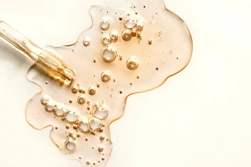 yellow texture of a drop of whey or olive oil on a white background transparent sample of cosmetic gel with bubbles golden acid cream vitamin c a drop of honey hyaluronic acid