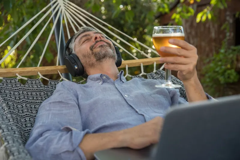 un homme d'âge mur se repose dans son hamac en écoutant de la