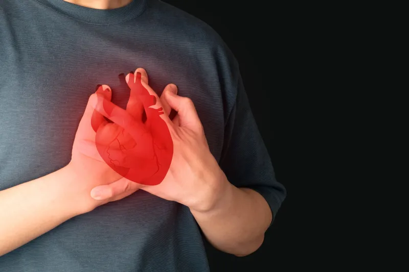 man suffering from chest pain, having heart attack with heart organ anatomy over black background warning signs of unstable angina, myocardrial infarction, coronary artery disease cardiological
