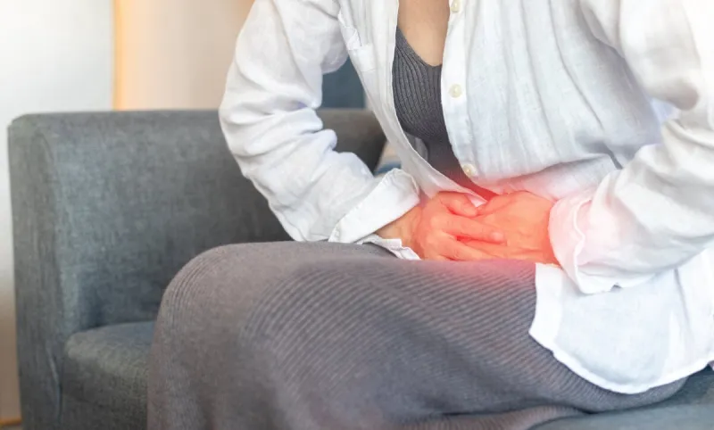 pelvic pain stomachache medical healthcare concept hands of young woman on stomach as pain or ache from menstruation cramp, indigestion, gastrointestinal, diarrheas or female diseases problem