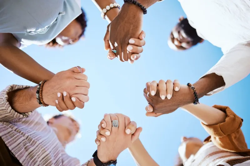diversity, people and hands in support, trust and unity for community against sky background diverse group hand holding together in united team building collaboration and teamwork solidarity success