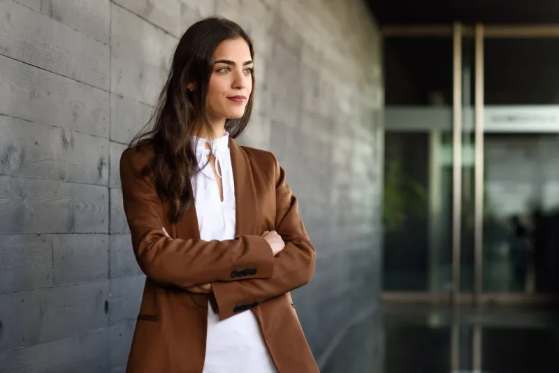 young businesswoman standing outside of office building beautiful woman wearing formal wear young girl with brown jacket and trousers