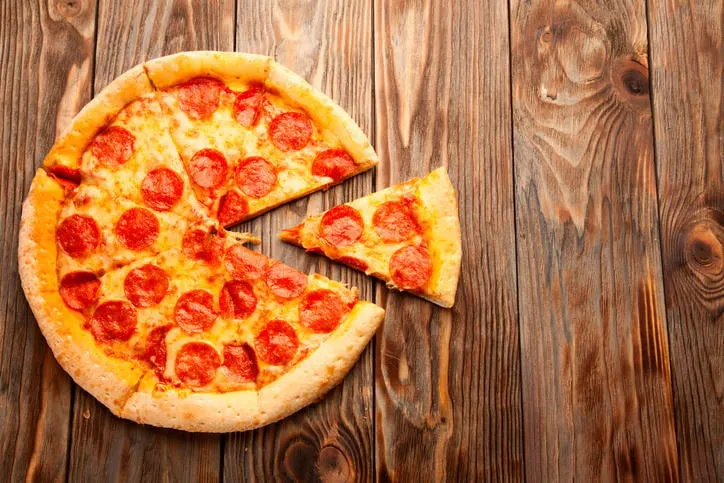 pizza au pepperoni sur une table en bois