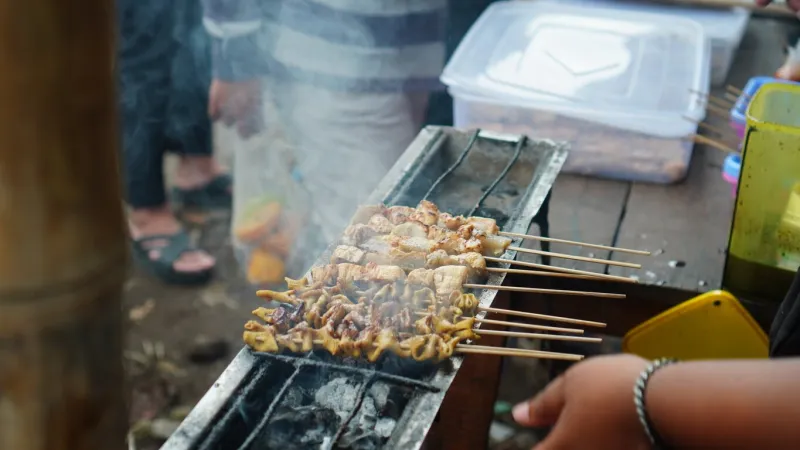 street vendors were grilling chicken intestine skewers and tofu for customers who had queued up
