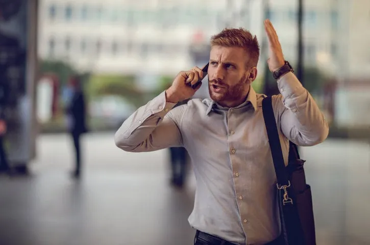 angry businessman on the street arguing with someone over cell phone