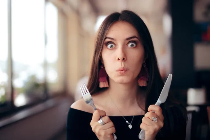greedy impatient girl waiting for her dish in a restaurant