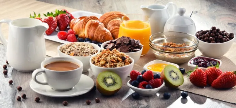 breakfast served with coffee, orange juice, croissants, cereals and fruits balanced diet