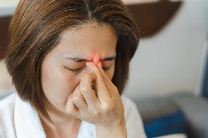 sinus,sinusitis, or rhinosinusitis concept asia woman suffer from headache, thick nasal mucus, and face pain symptoms