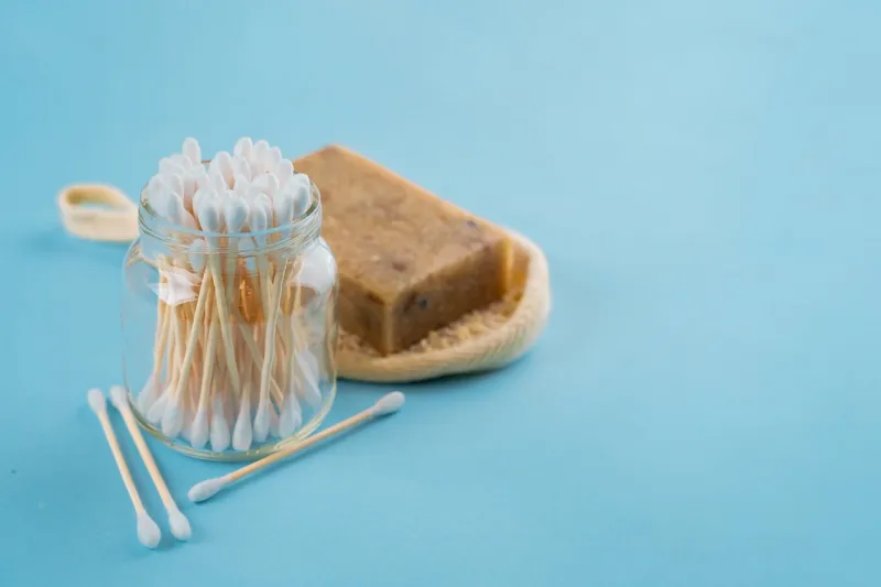 bath set - sponge luffa, bamboo sticks ear on blue background concept less waste
