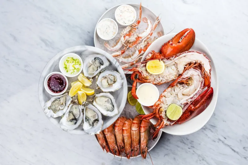 fresh seafood platter with lobster, mussels and oysters on marble desk