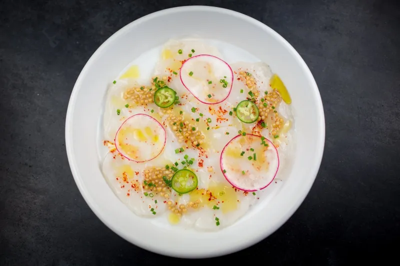 scallop carpaccio with espellete pepper, lemon, extra virgin olive oil, serrano chiles and pickled mustards seeds