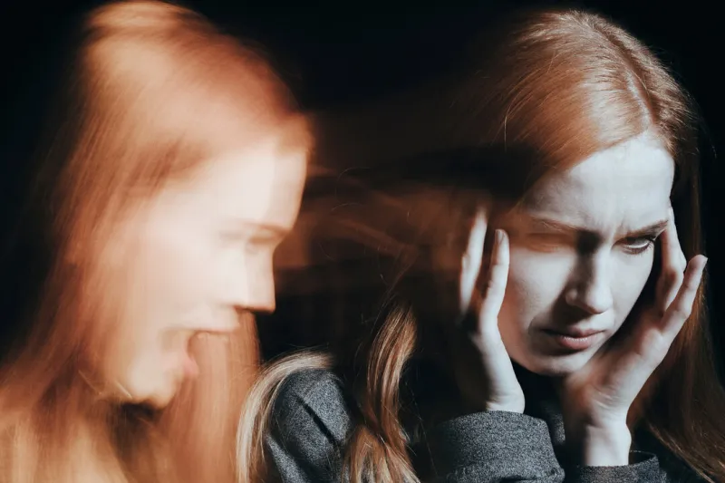 sick woman with schizophrenia hearing voices blurred person