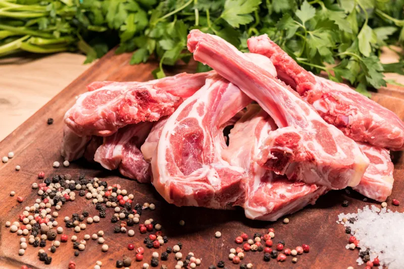 raw lamb chops on a wooden board for barbecue