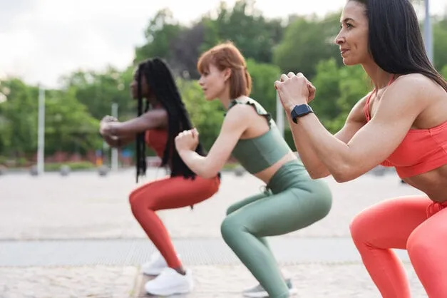 three diverse ethnicity girls exercising together outdoors in the city