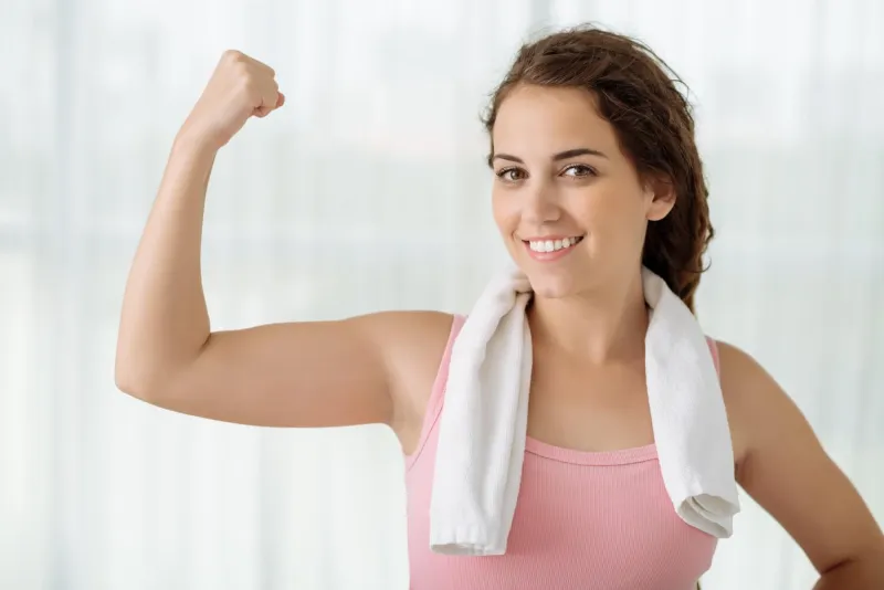femme athlétique souriante, fléchissant son concept de remise en forme et de régime biceps