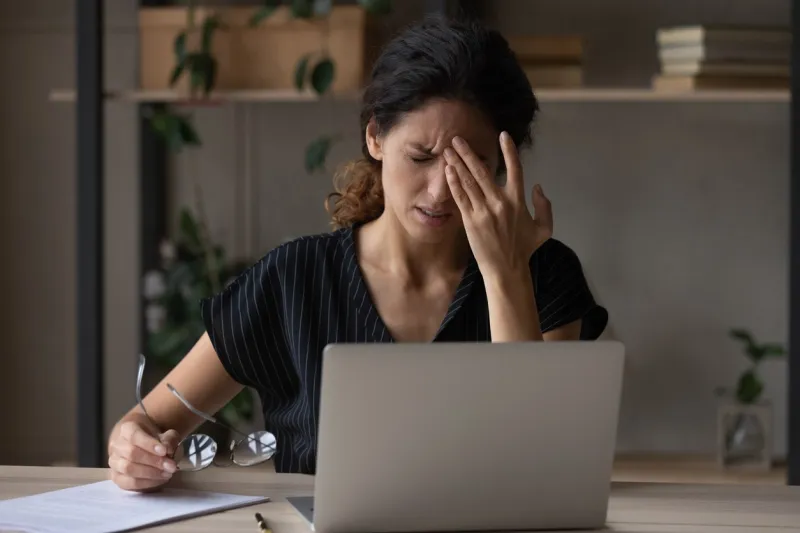 unwell young caucasian woman work on computer at home office take off glasses suffer from migraine or headache unhappy tired millennial female struggle with dizziness or blurry vision using laptop