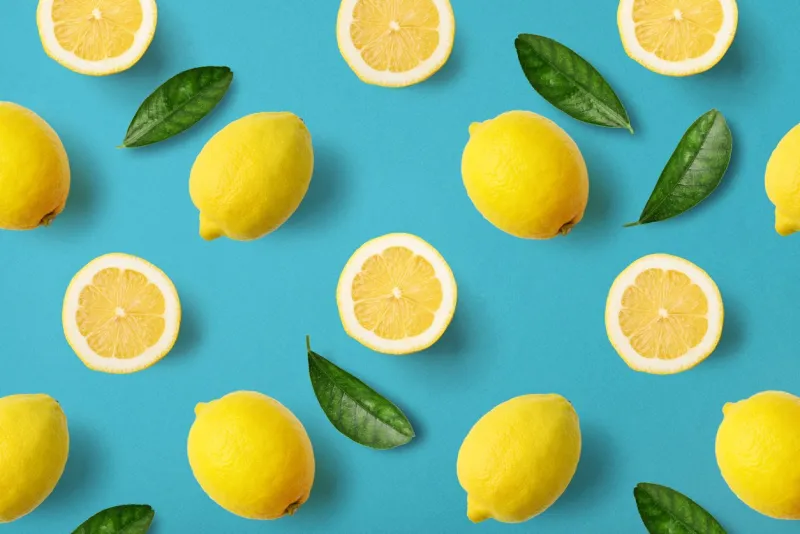 colorful fruit pattern of lemons on blue background, top view
