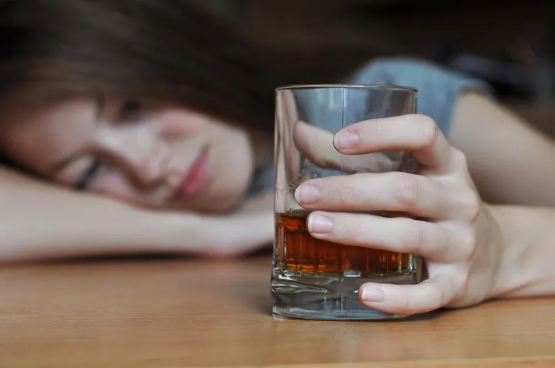 drunk female with a glass of whiskey