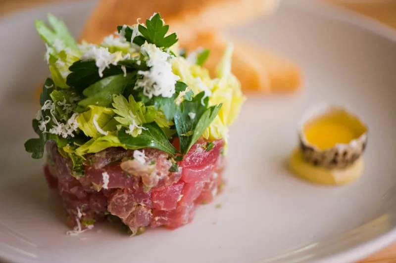 tuna tartare classic american restaurant or bistro appetizer classic sushi grade ahi tuna, diced, mixed w  eggs, red onions, olive oil, lemon juice, garlic & capers served w  garlic bread