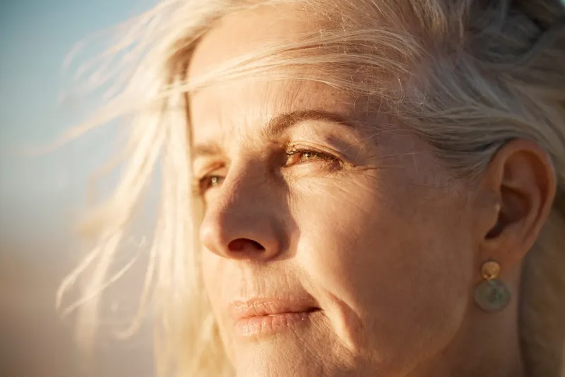 closeup on the face of a mature woman on the beach beautiful senior woman enjoying the view on the beach face of a beautiful senior woman enjoying the view mature woman on holiday by the sea