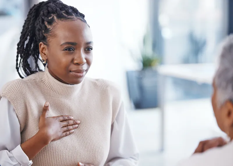 healthcare, patient and black woman with chest pain, sick and speaking to a doctor, hospital and illness female model, person or lady with heart problem, issue and medical professional with advice