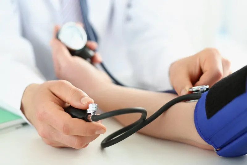 close-up of doctor check blood pressure of patient in clinic, risk of hypertension, prevent disease work with stethoscope tool medicine, health concept