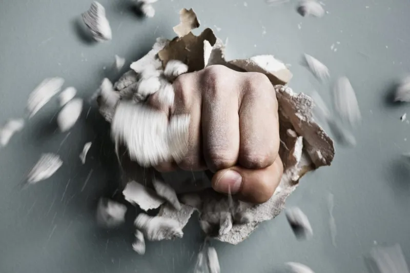 a wall is broken through by a fist