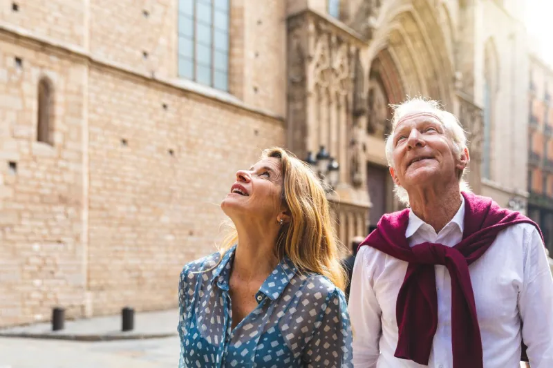 senior couple of tourists visiting the old town in barcelona adult woman and man looking up at some beautiful architecture on a sunny day in spain travel and tourism concepts