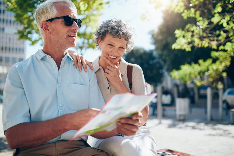 senior couple using a city map for location in the town mature man and woman sitting outdoors in city with a map