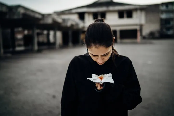sick woman holding bloody tissuecough with bloodinfectious disease victimill person having lethal respiratory diseaseattacked immune systemsymptoms of severe tissue damageviral fever