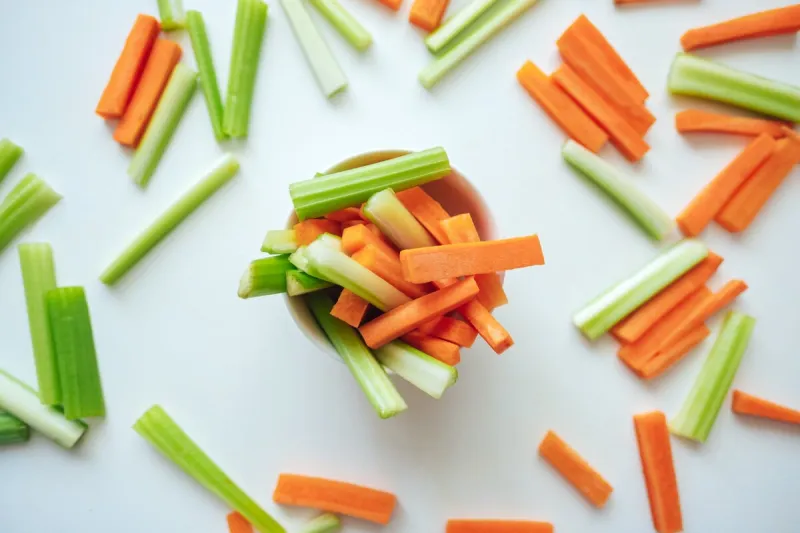 sliced carrots and celery in a white bowl, healthy food, recipe background high quality photo