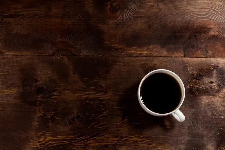 une tasse blanche de fond de café en bas à droite de l'avion