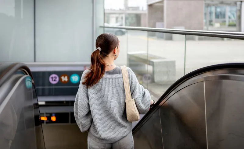 young woman going down the escalator in the metro