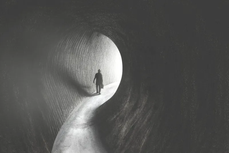 solitary man getting out of dark tunnel toward the light, hope concept