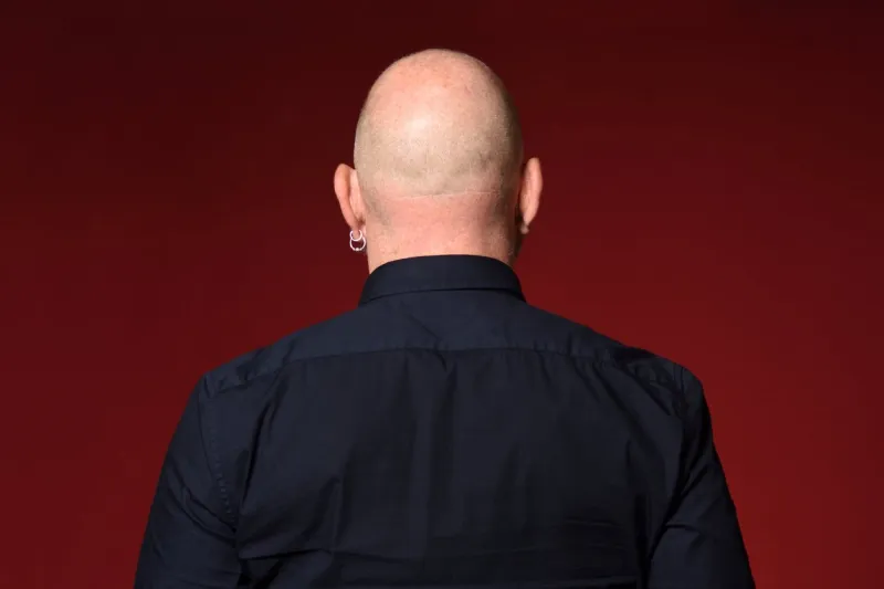 portrait of a bald man,rear view,on red background