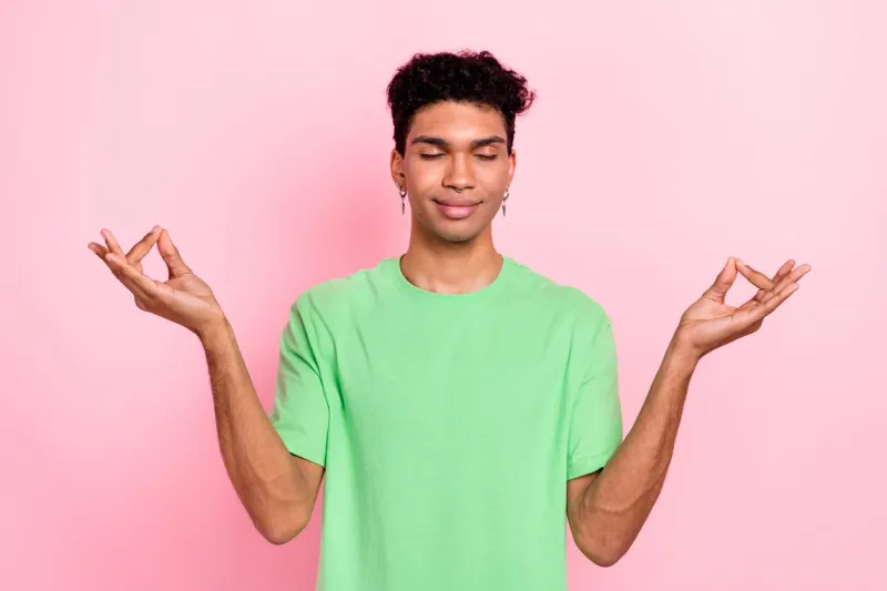 photo of nice calm man dressed trendy green clothes hand demonstrate om yoga sign isolated on pink color background