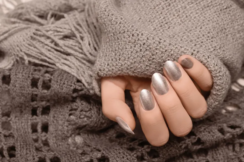 female hands with gold nail design red nail polish manicured hands woman hands hold brown wool shawl