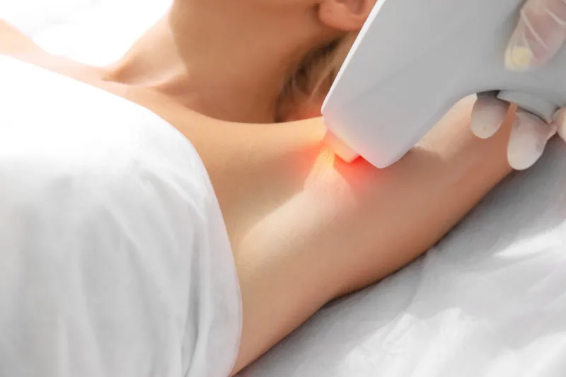 woman getting laser treatment on her armpit in a beauty salon, close up