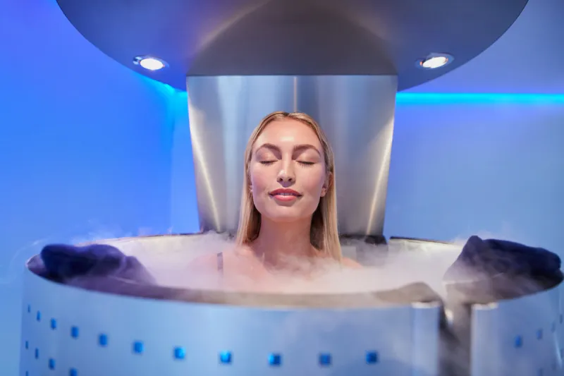portrait of happy young woman in a whole body cryotherapy cabin with her eyes closed cryosauna chamber for overall increase in muscular performance