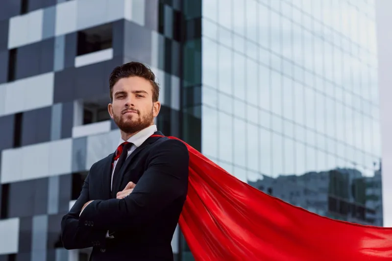 businessman in a superhero costume against a business building background