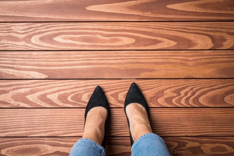 woman standing on wooden floor top view