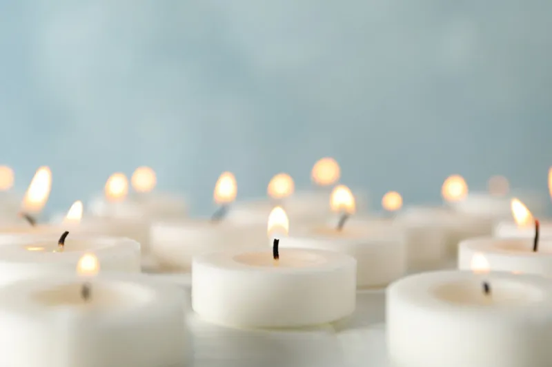 group of burning candles against blue background, close up