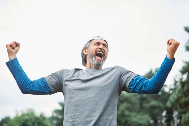 senior man running exercising sport fitness screaming power strength anger champion