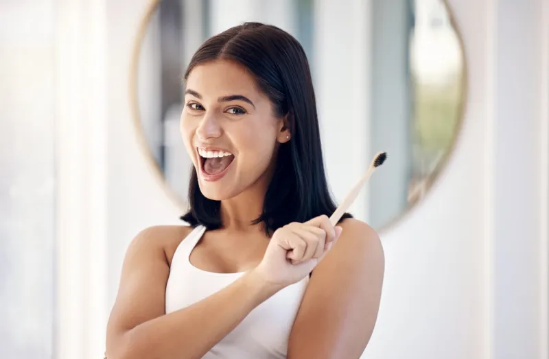 brushing teeth, woman and portrait of bamboo toothbrush, dental wellness and healthy lifestyle, cleaning and cosmetics in bathroom happy female with eco friendly wooden brush product for mouth smile