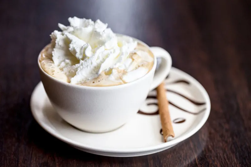 cup of whipped cream vienna coffee with cinnamon stick
