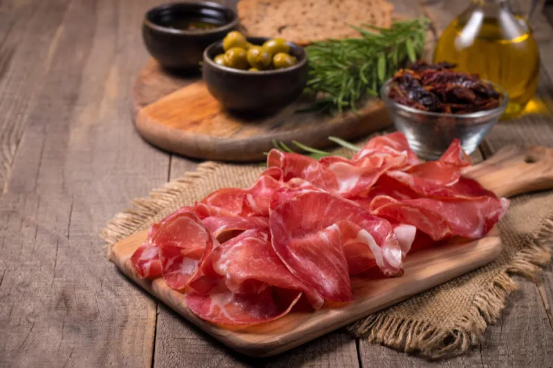 italian slices of coppa, capocollo, capicollo, bresaola or cured ham with rosemary raw food